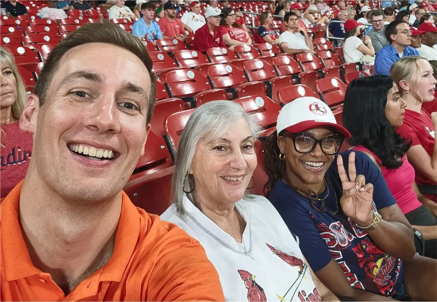 Jared Young se toma una selfie con dos hinchas de los Cardinals en los asientos rojos del Busch Stadium