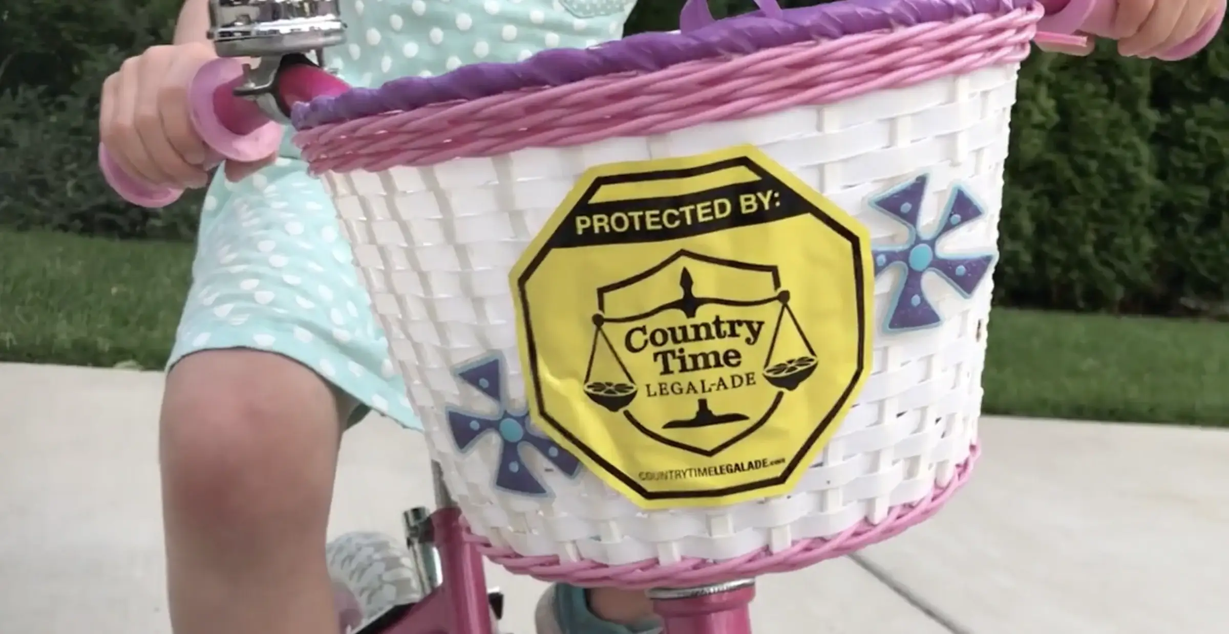Insignia “Protected by Country Time Legal-Ade” en la canasta de una bicicleta (captura de la película del caso)