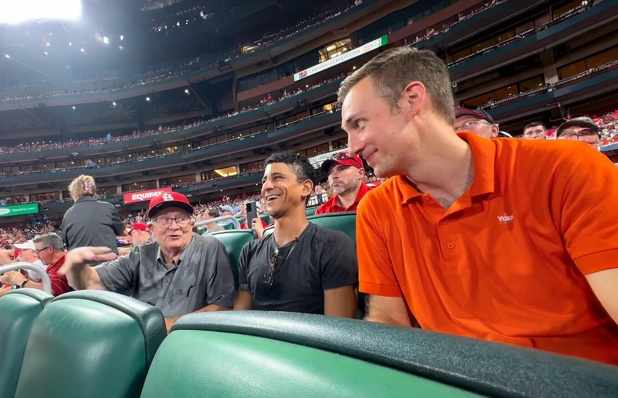 Jared Young, con camisa naranja, se une a John y Julian en sus asientos del Busch Stadium