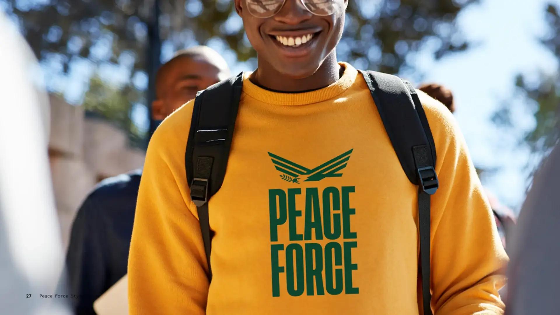 Smiling student in a gold Peace Force sweatshirt