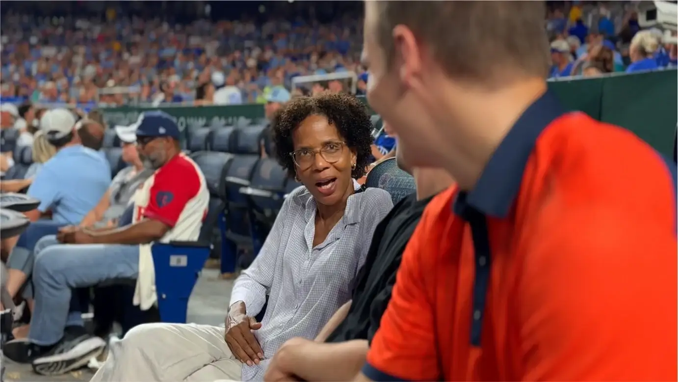 Kirby le sonríe a Jared Young, de polo naranja, mientras conversan durante el partido de los Royals